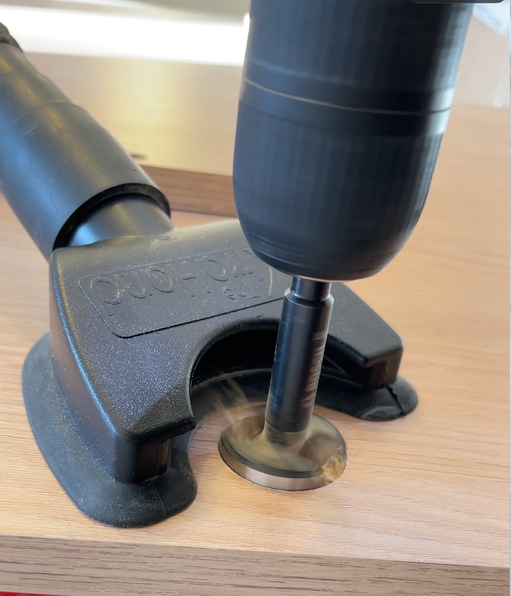 The genuine XtraHand sucking away the dust and debris from drilling with a 35mm Forstner bit in veneered chipboard