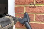 Using the Genuine XtraHand® hands-free dust extraction tool while drilling into a red brick wall to install a Ring Doorbell. Captures brick dust at source for cleaner, safer masonry drilling and improved visibility.